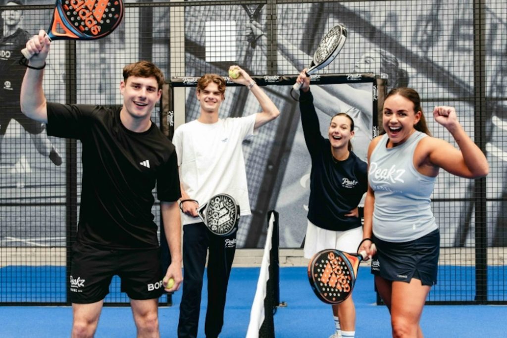 Vier spelers juichen op de padelbaan