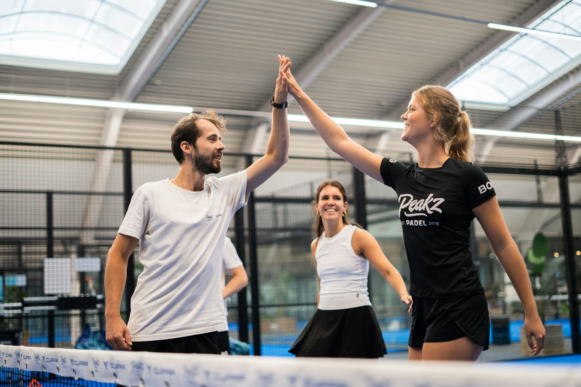 Spelers geven elkaar een high five na een partij padel